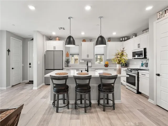 a kitchen with stainless steel appliances kitchen island granite countertop a kitchen island hardwood floor and a sink