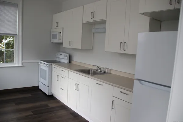 a kitchen with granite countertop white cabinets and sink