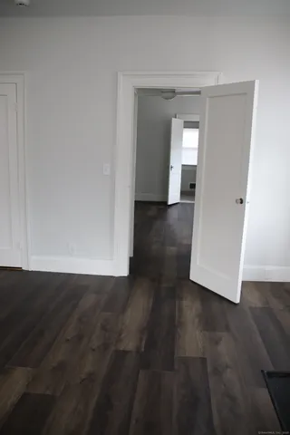 an empty room with wooden floor and cabinet