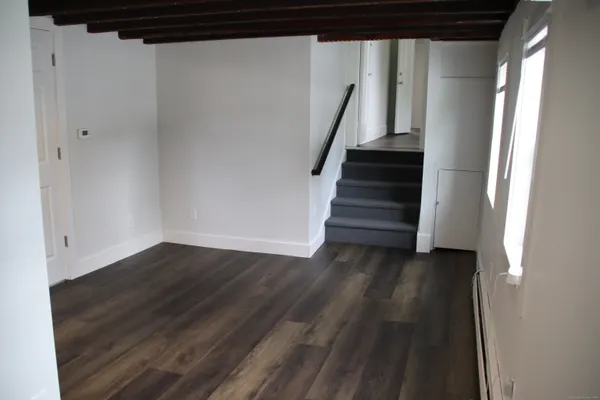 a view of a hallway with wooden floor and stairs