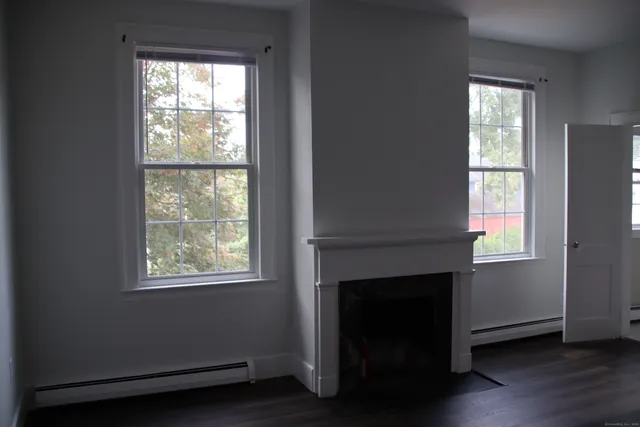 a living room with a fireplace and windows