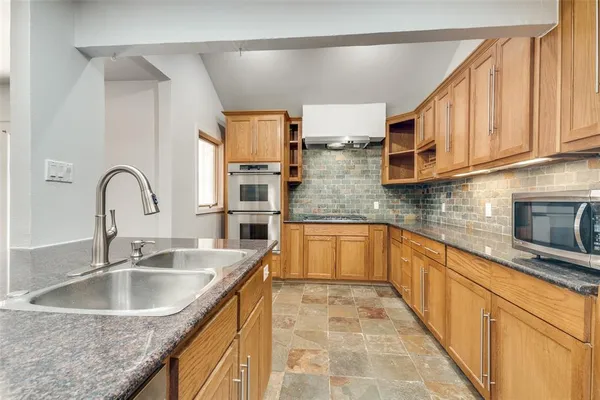 a kitchen with stainless steel appliances granite countertop a sink stove and cabinets