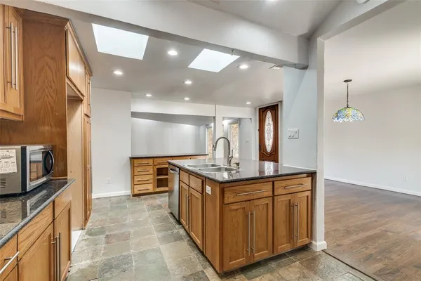 a kitchen with stainless steel appliances granite countertop a sink and a stove