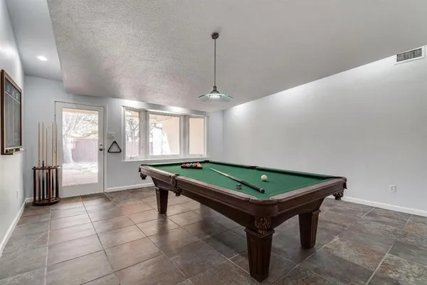 a room with pool table and windows