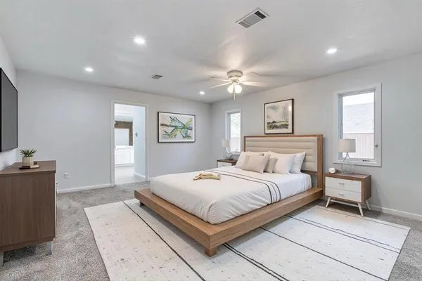 a bedroom with a large bed and a chandelier