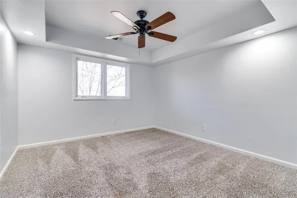 an empty room with windows and ceiling fan