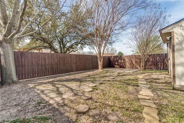 a backyard of a house with trees and wooden fence