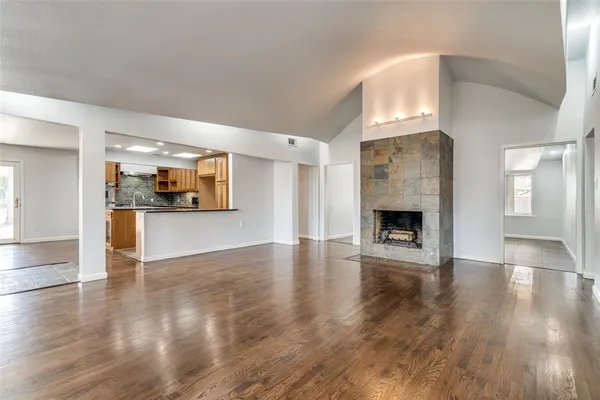 a view of a livingroom with wooden floor and a fireplace