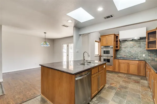 a kitchen with stainless steel appliances granite countertop a sink stove and cabinets
