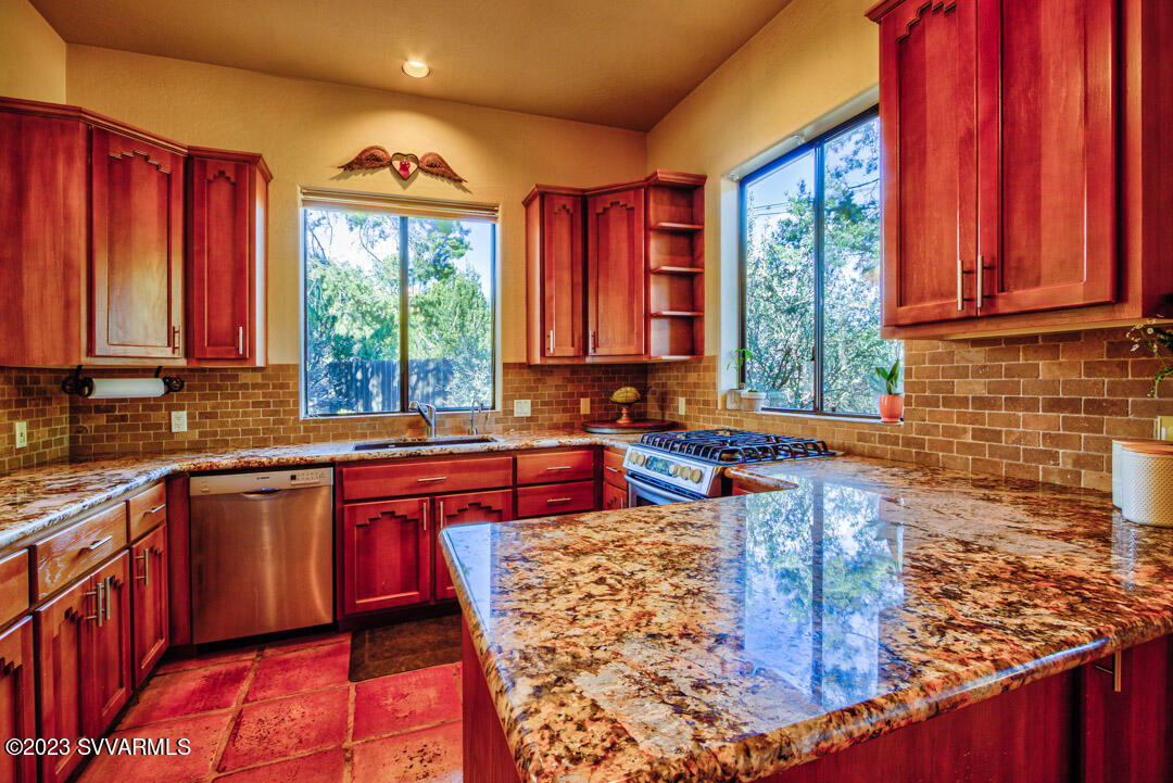 55 Roundup Road Sedona, AZ 86336 - Photo 18 of 35 a kitchen with stainless steel appliances granite countertop a stove sink and cabinets