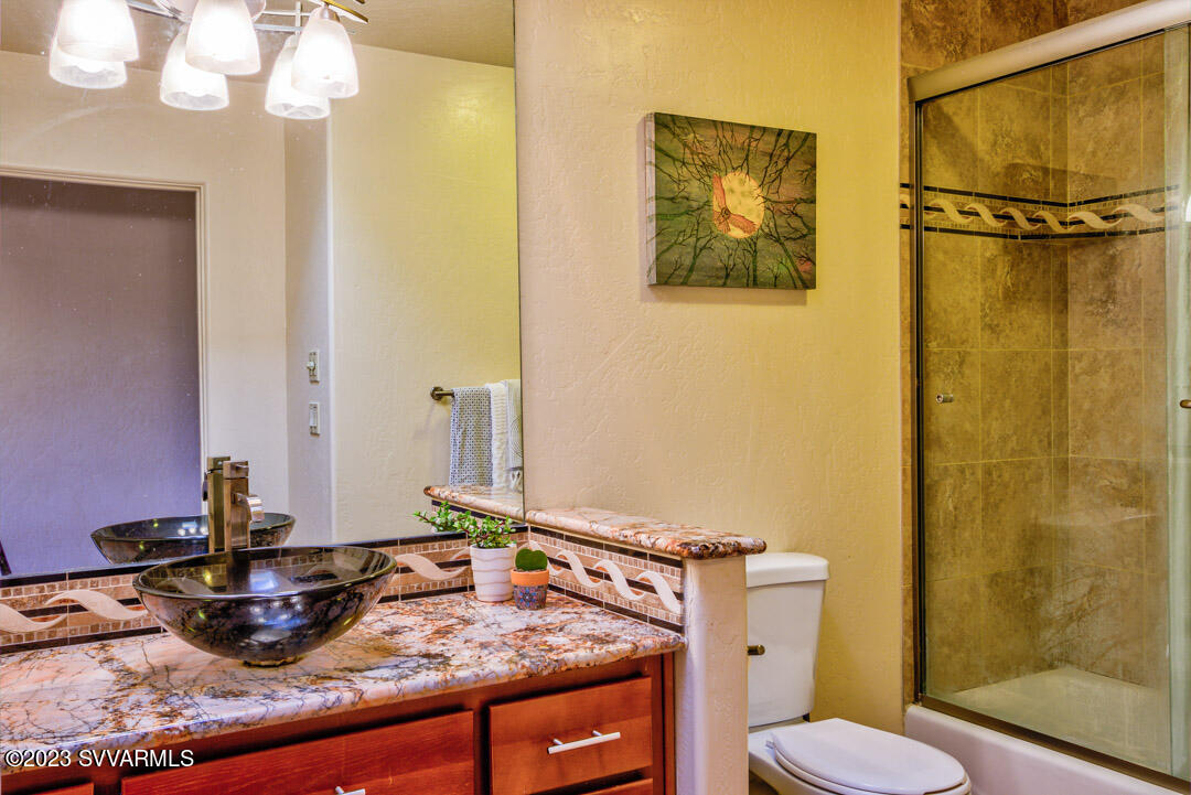 55 Roundup Road Sedona, AZ 86336 - Photo 27 of 35 a bathroom with a granite countertop sink mirror vanity and toilet