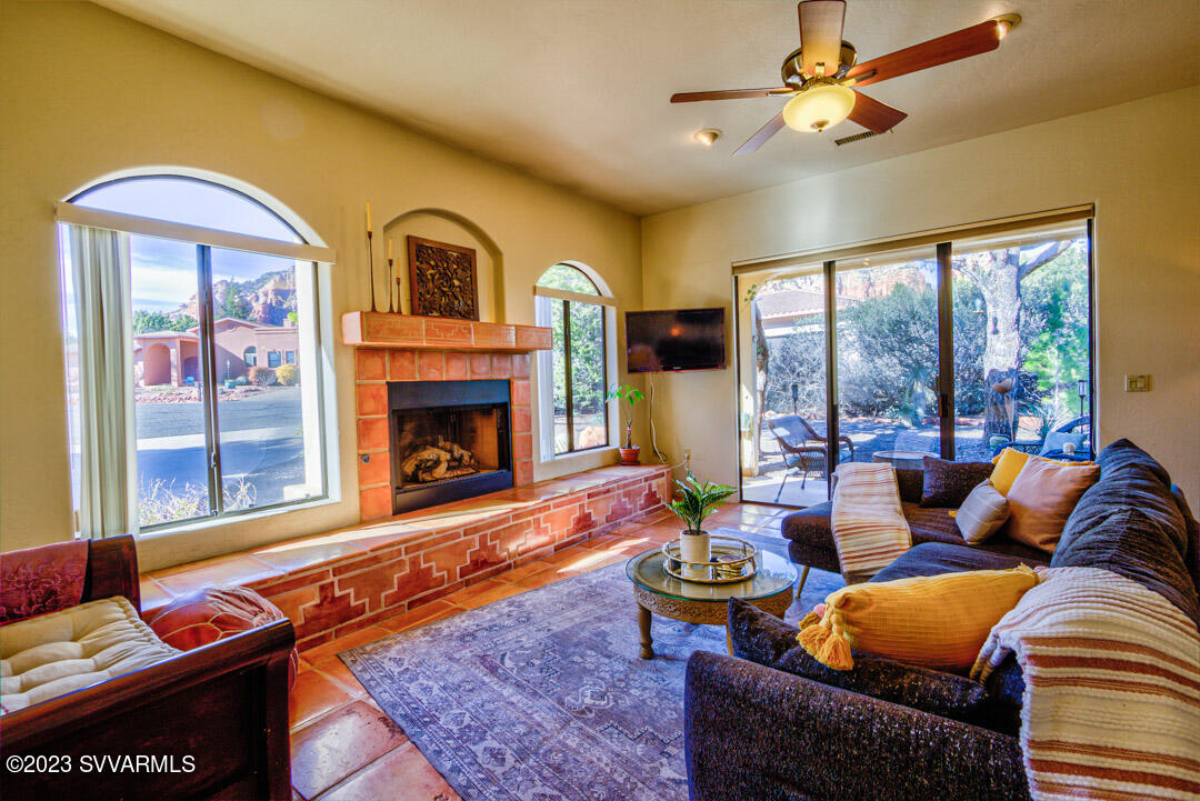 55 Roundup Road Sedona, AZ 86336 - Photo 8 of 35 a living room with furniture a fireplace and a floor to ceiling window