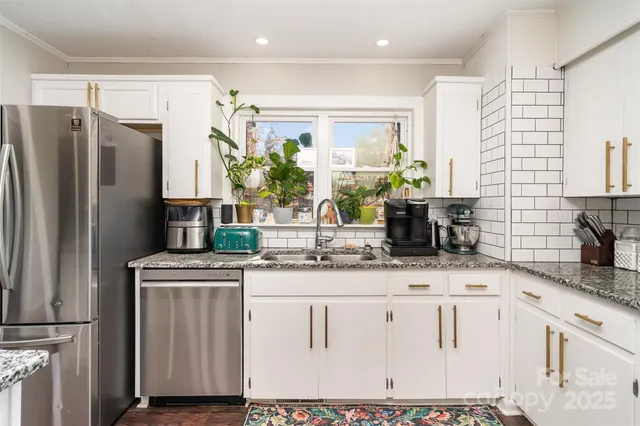 a kitchen with stainless steel appliances a sink stove and refrigerator