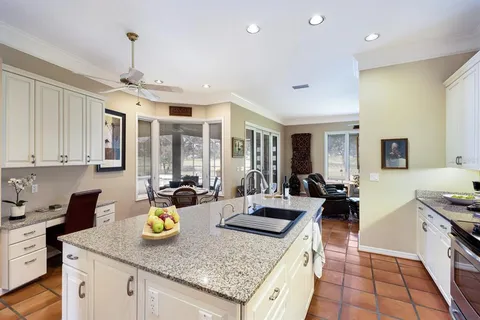 a open kitchen with granite countertop a sink stove and cabinets