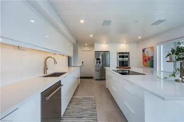 a large kitchen with stainless steel appliances granite countertop a sink and cabinets