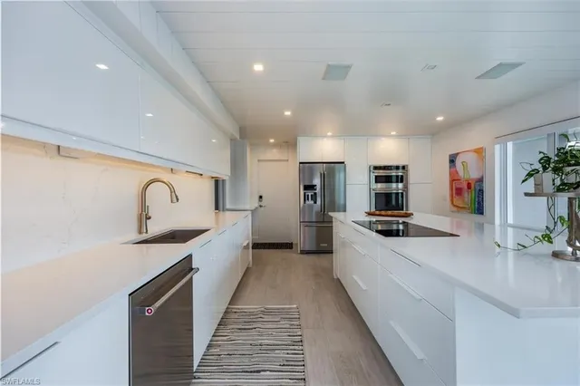 a large kitchen with stainless steel appliances granite countertop a sink and cabinets
