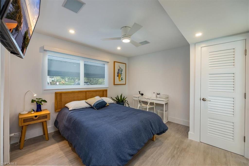 1100 8th Avenue South, Unit 123F Naples, FL 34102 - Photo 19 of 30 a bedroom with a bed a mirror and a window