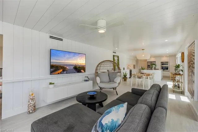 a living room with furniture a mirror and view of kitchen