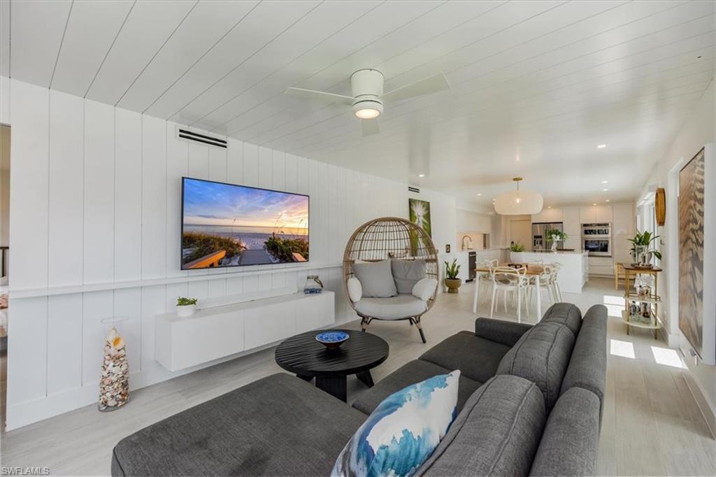 1100 8th Avenue South, Unit 123F Naples, FL 34102 - Photo 3 of 30 a living room with furniture a mirror and view of kitchen