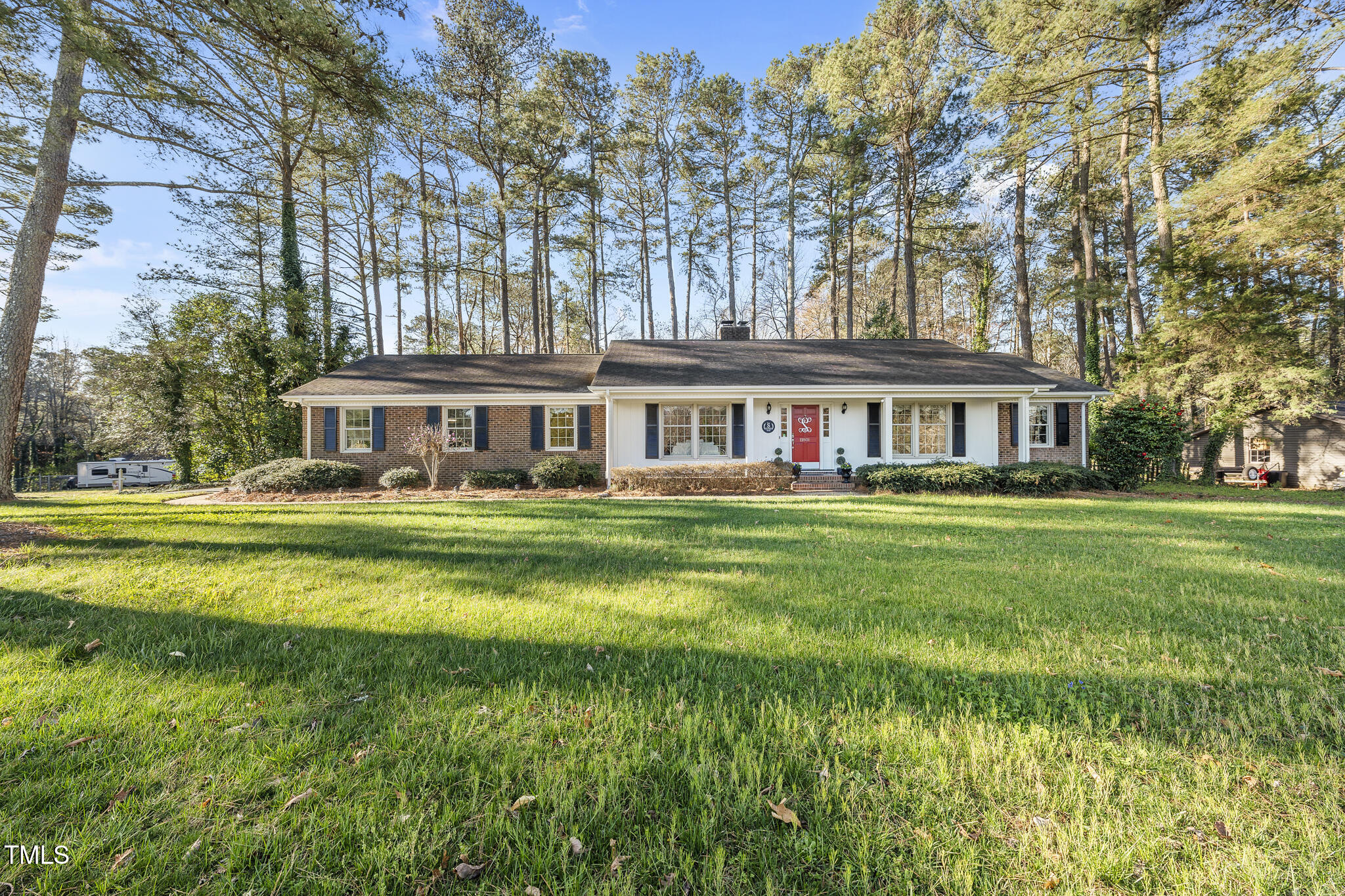 11801 Strickland Road Raleigh, NC 27613 - Photo 1 of 38 a front view of a house with a yard table and chairs