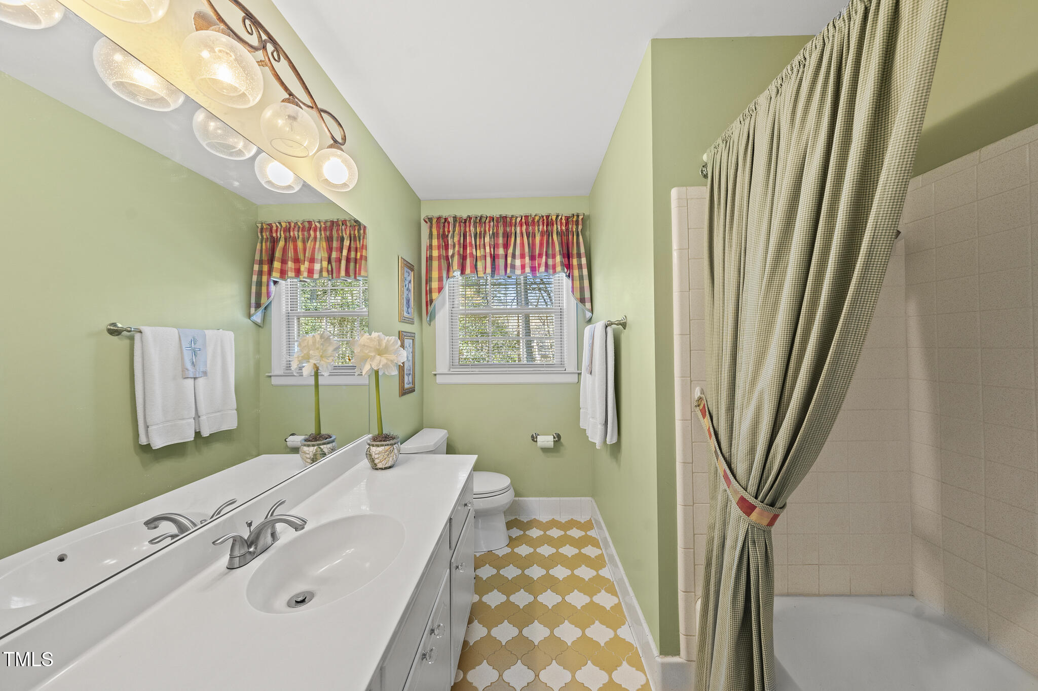 11801 Strickland Road Raleigh, NC 27613 - Photo 19 of 38 a spacious bathroom with a sink a mirror and a shower