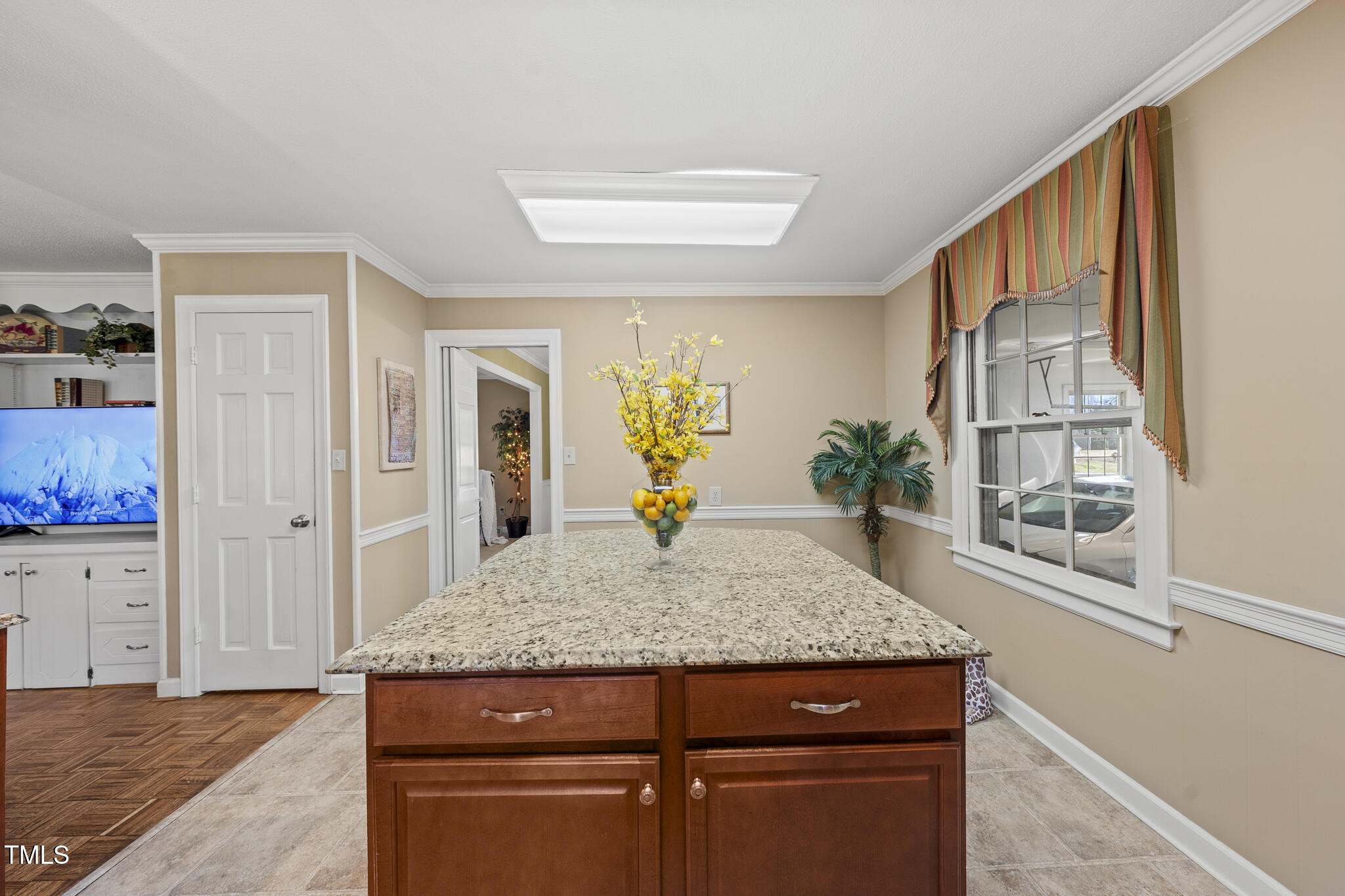 11801 Strickland Road Raleigh, NC 27613 - Photo 31 of 38 a living room with kitchen island granite countertop wooden floor and staircase
