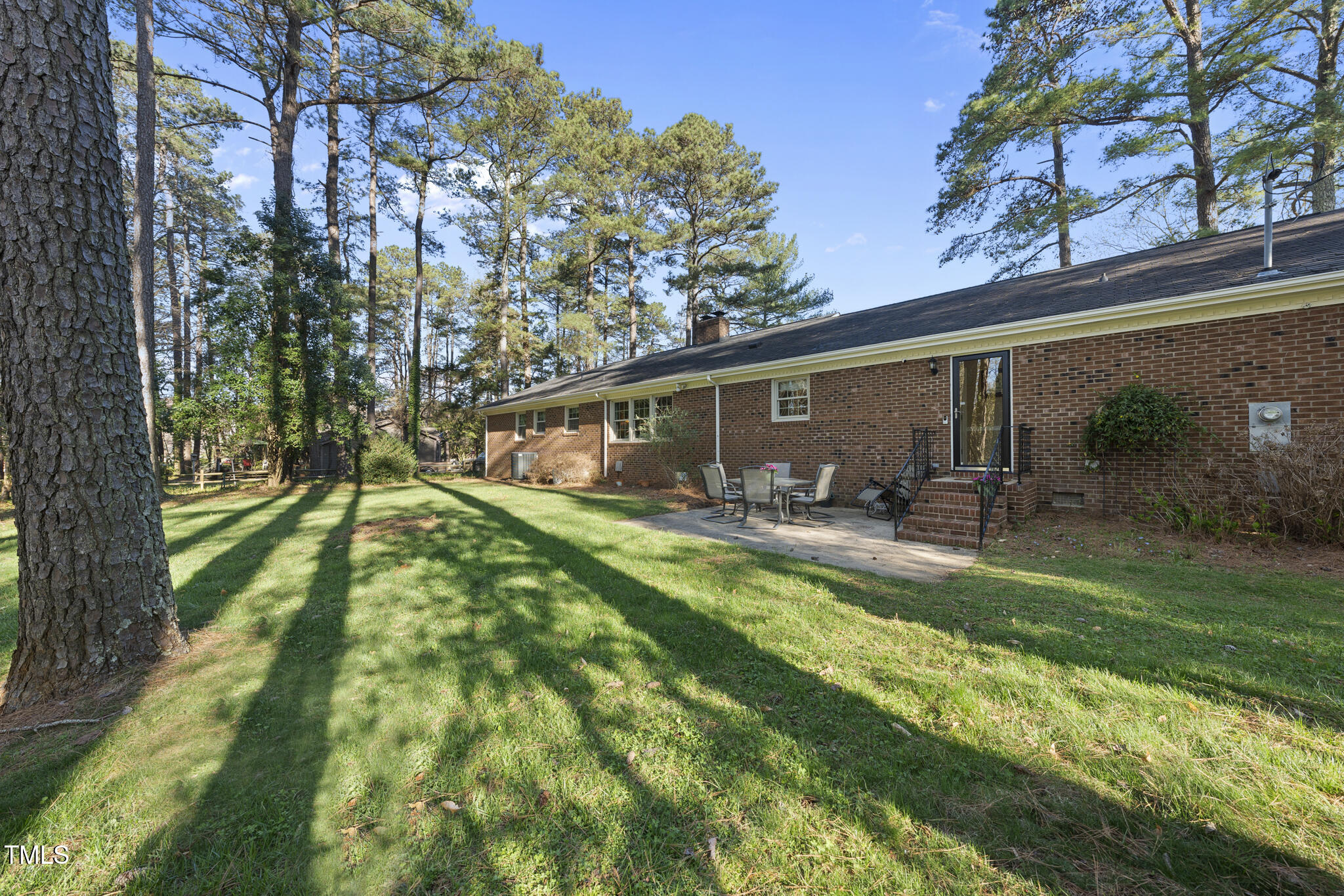 11801 Strickland Road Raleigh, NC 27613 - Photo 37 of 38 a view of a backyard with table and chairs potted plants and large tree