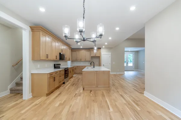 a large kitchen with kitchen island lots of counter space a sink appliances and cabinets