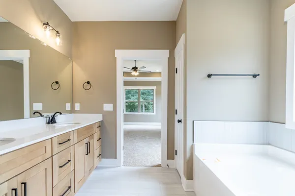 a bathroom with a tub a sink and mirrors