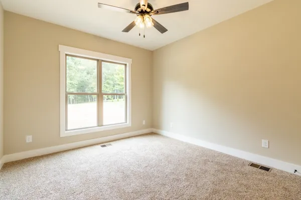 an empty room with a window and a fan