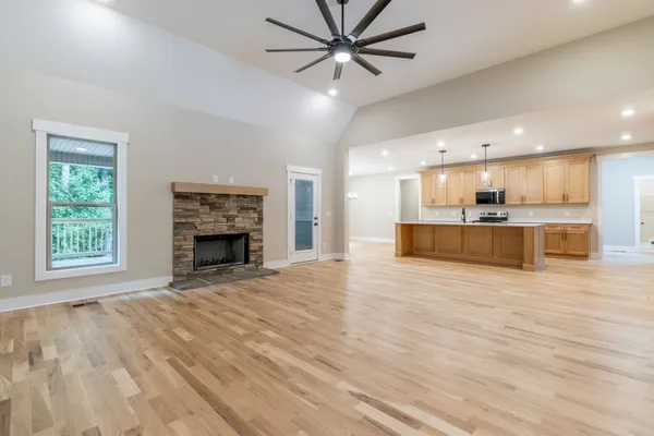 a view of an empty room with a kitchen and a window