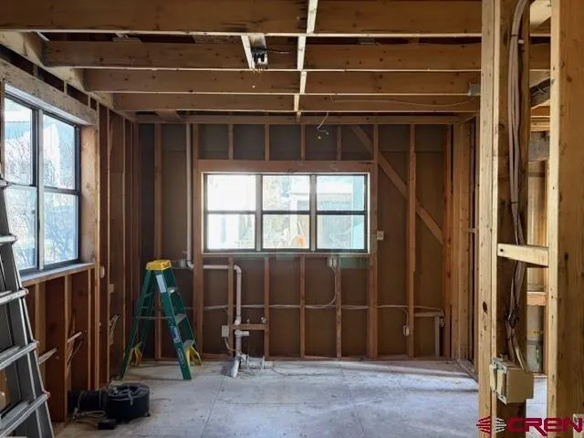 a kitchen with stainless steel appliances granite countertop a stove top oven a sink a dining table and chairs with wooden floor