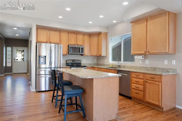 a kitchen with stainless steel appliances granite countertop a stove a sink a refrigerator and cabinets