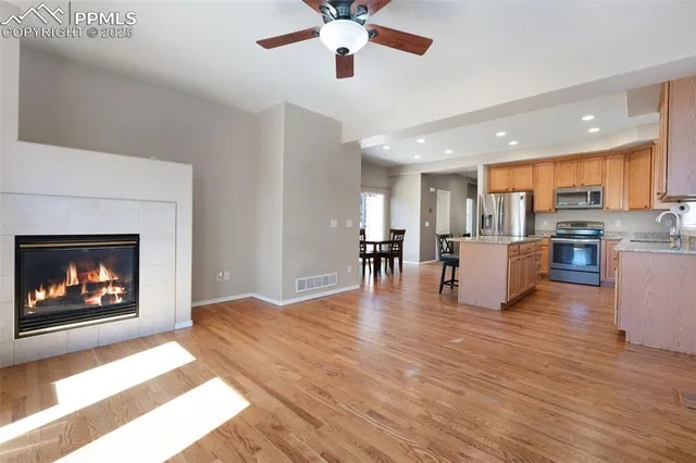 a living room with furniture a fireplace and kitchen view
