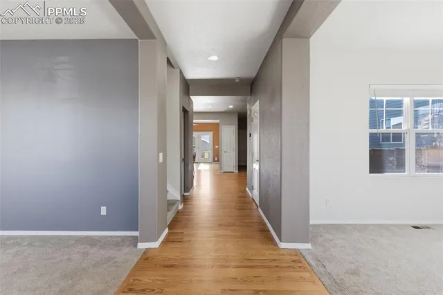 a view of a hallway with wooden floor and staircase