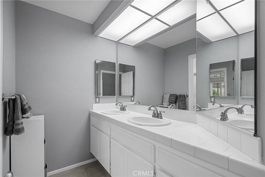 27251 Blakely Place Valencia, CA 91354 - Photo 22 of 31 a bathroom with a double vanity sink and mirror