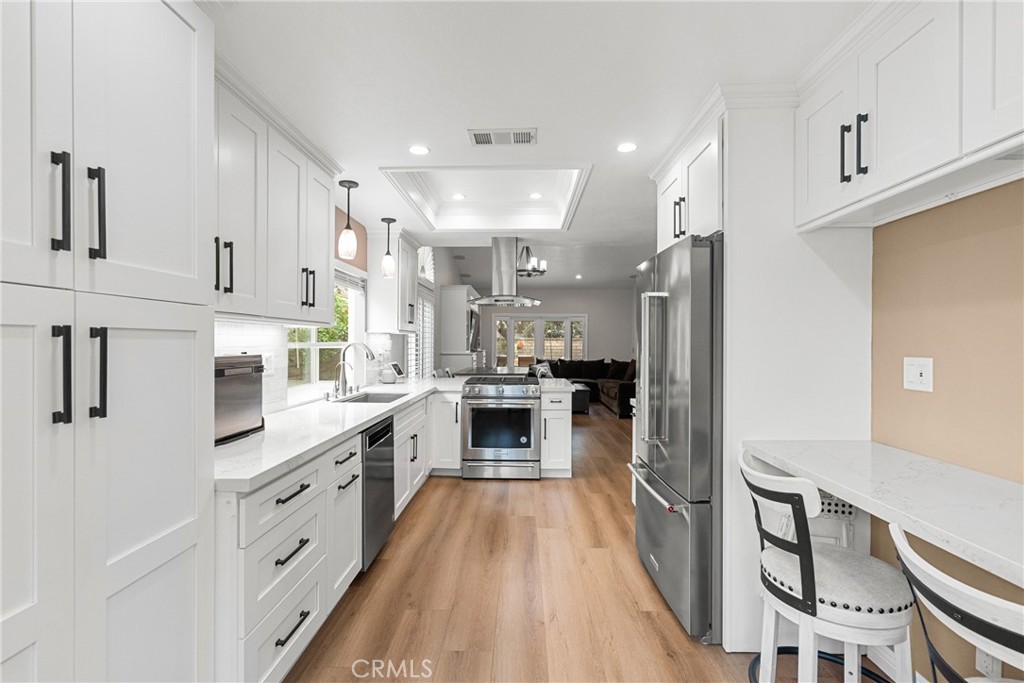 27251 Blakely Place Valencia, CA 91354 - Photo 6 of 31 a large kitchen with stainless steel appliances granite countertop a lot of counter space and wooden floors