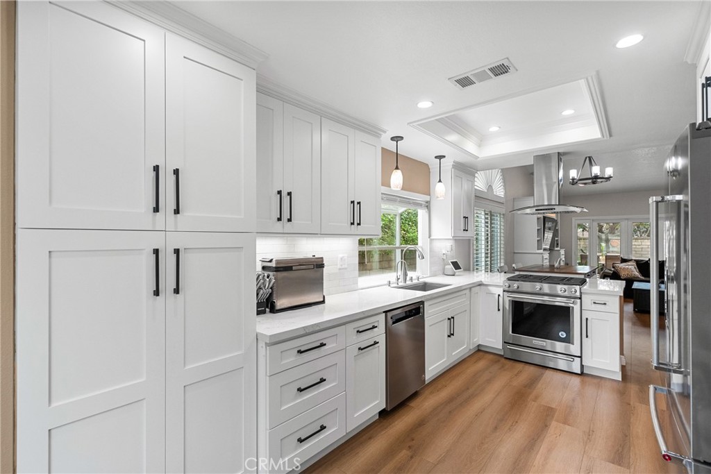 27251 Blakely Place Valencia, CA 91354 - Photo 7 of 31 a kitchen with white cabinets stainless steel appliances and sink