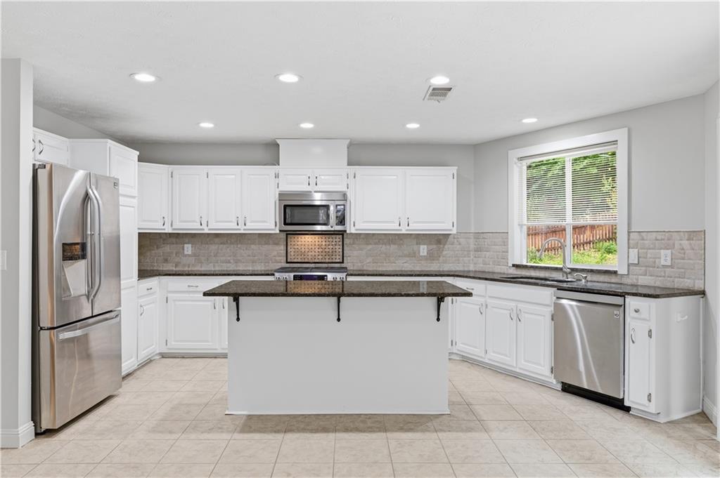 2824 Carriage Rowe Duluth, GA 30096 - Photo 14 of 45 a kitchen with stainless steel appliances granite countertop a stove top oven a sink and a refrigerator
