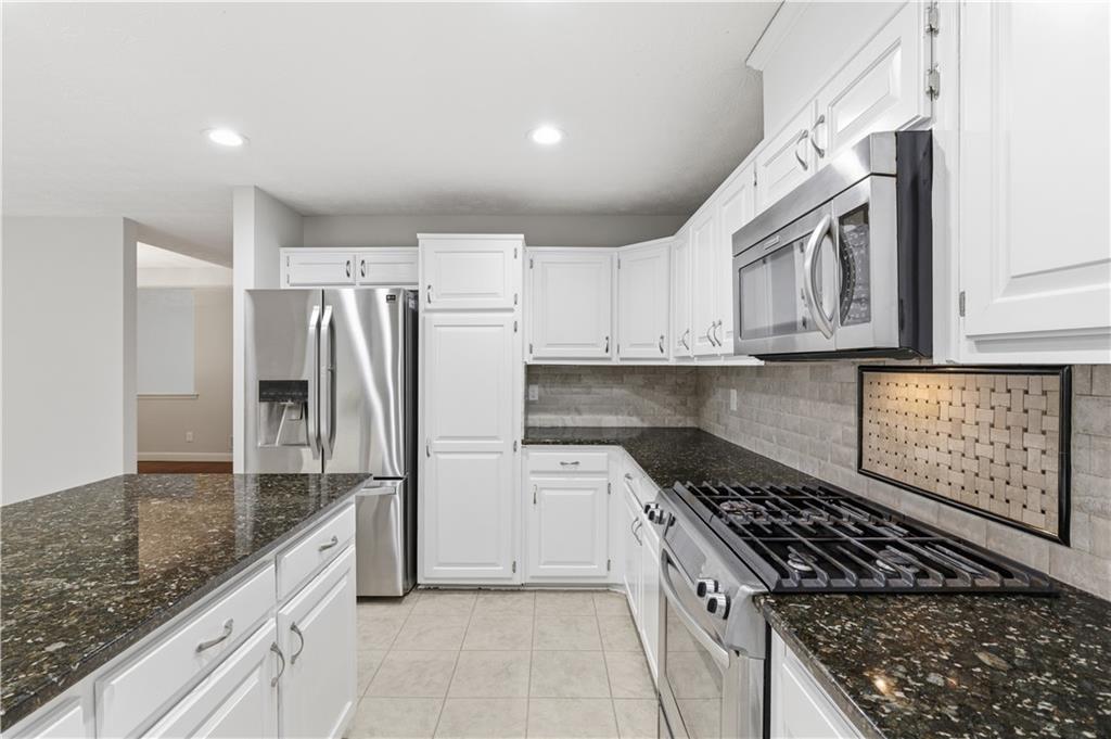 2824 Carriage Rowe Duluth, GA 30096 - Photo 16 of 45 a kitchen with stainless steel appliances granite countertop a refrigerator and a stove
