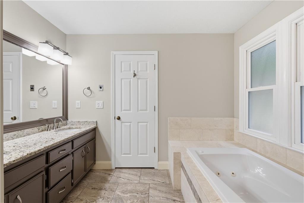 2824 Carriage Rowe Duluth, GA 30096 - Photo 23 of 45 a spacious bathroom with a granite countertop tub sink and mirror