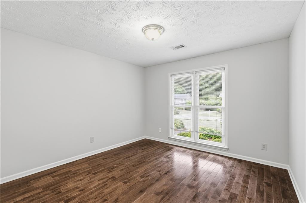 2824 Carriage Rowe Duluth, GA 30096 - Photo 26 of 45 an empty room with wooden floor and windows