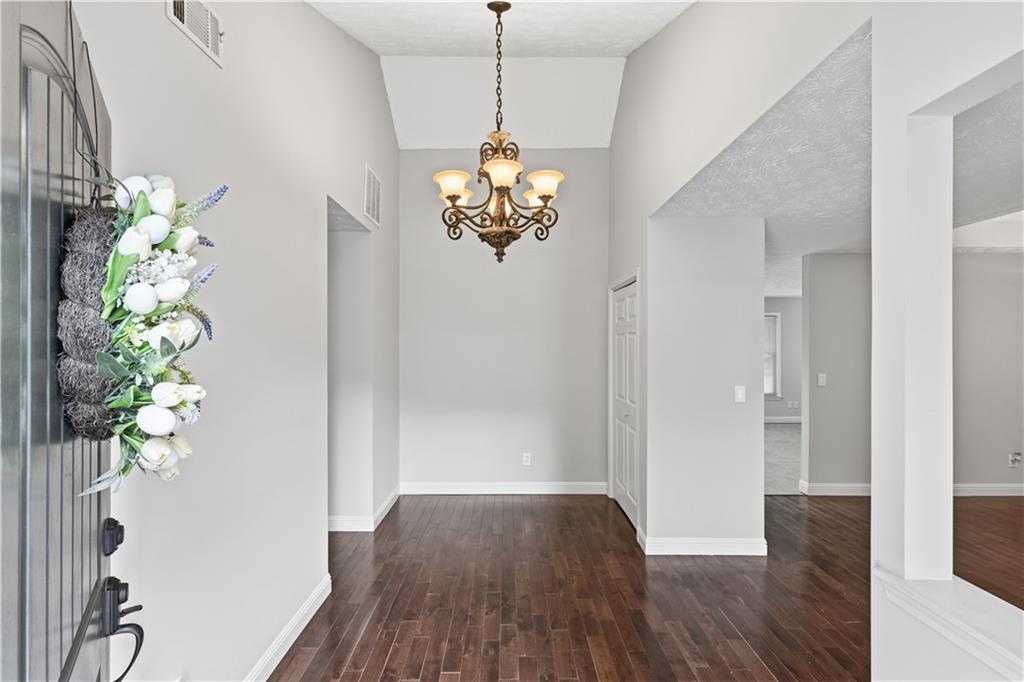 2824 Carriage Rowe Duluth, GA 30096 - Photo 4 of 45 a view of a hallway with wooden floor and a chandelier