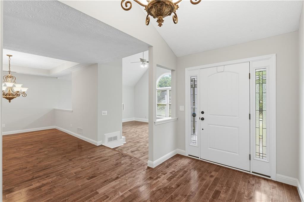 2824 Carriage Rowe Duluth, GA 30096 - Photo 5 of 45 an empty room with wooden floor and hallway