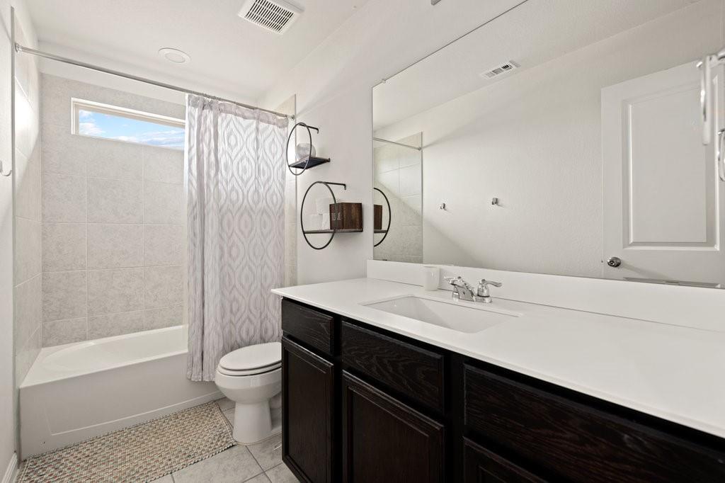8308 Daisy Cutter Crossing Georgetown, TX 78626 - Photo 25 of 27 A streamlined vanity and ample mirror space create a clean, functional primary bathroom.