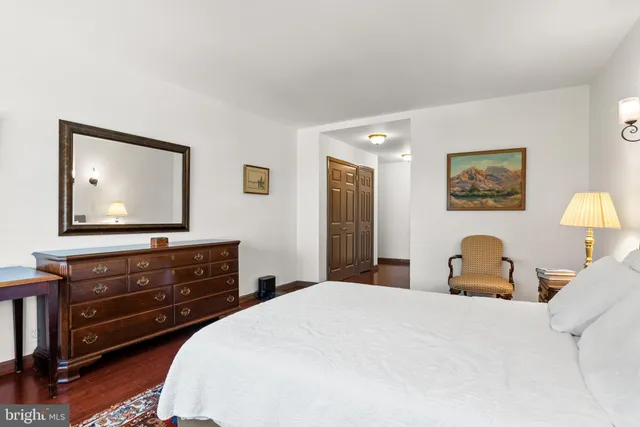 a bedroom with a bed and a flat tv screen on dresser
