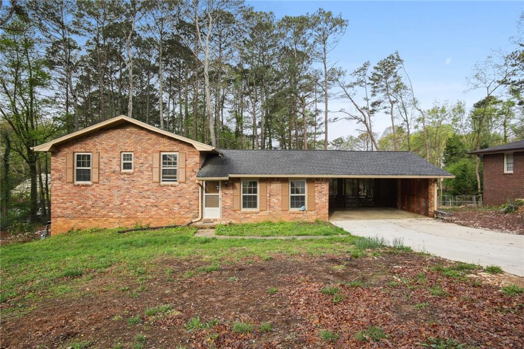 1497 Pine Street Southwest Stone Mountain, GA 30087 - Photo 1 of 1 a front view of a house with a yard and garage