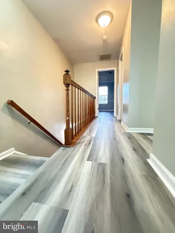 a view of a hallway with wooden floor