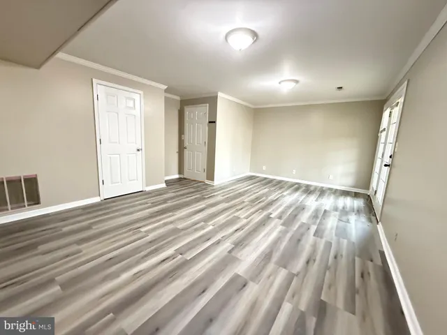 a view of an empty room with wooden floor