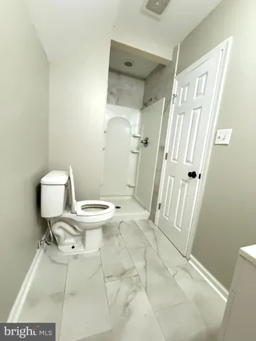 a white toilet sitting next to a bathroom sink